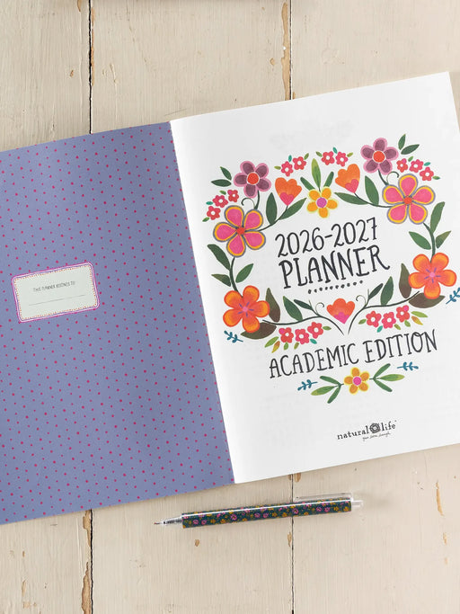 2026-2027 planner with floral design on a wooden surface