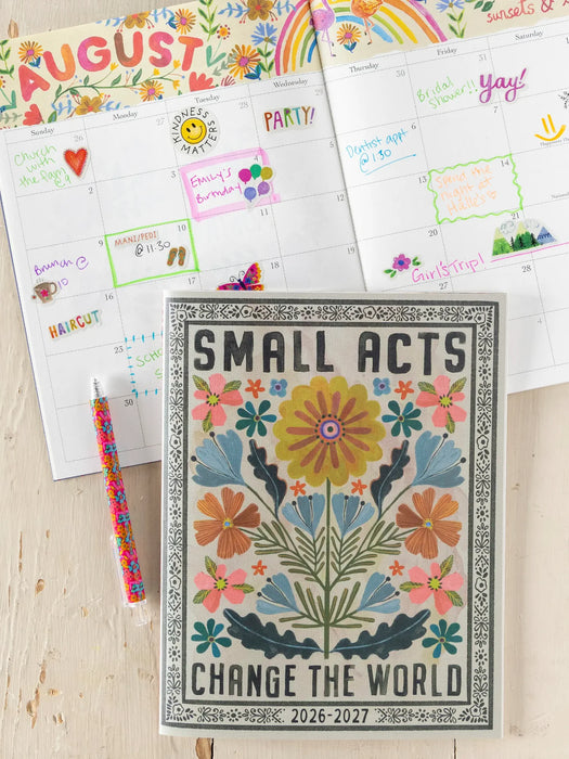 Calendar with floral design and motivational quote, surrounded by colorful planner pages.