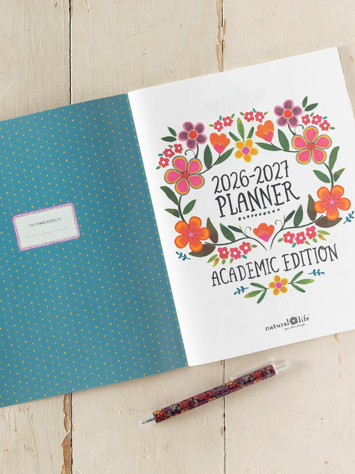 2026-2027 planner with floral design on a wooden surface