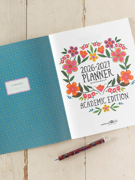 2026-2027 planner with floral design on a wooden surface