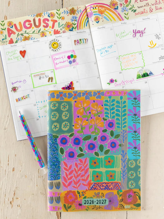 Colorful planner with floral design and text on a wooden surface
