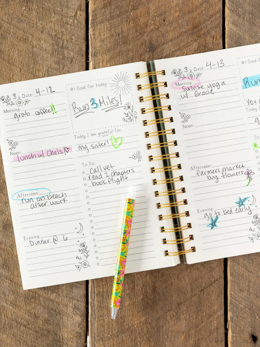 Open planner with daily entries on a wooden surface