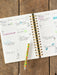 Open planner with daily entries on a wooden surface