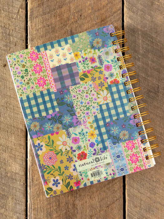 Notebook with floral and checkered pattern on wooden surface