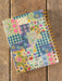 Notebook with floral and checkered pattern on wooden surface