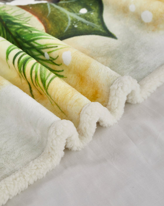 Close-up of a folded blanket with green leaf pattern on a light background