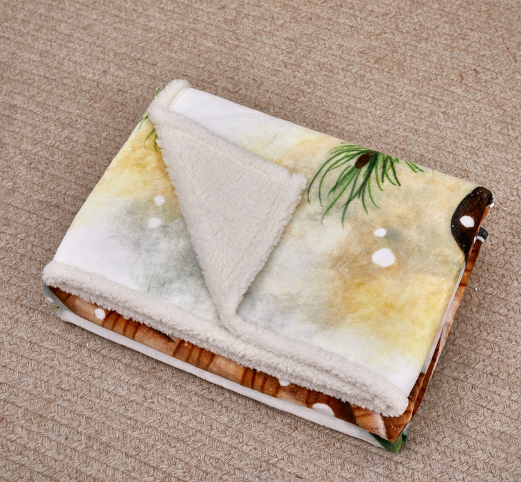 Folded blanket with nature-themed design on a beige carpet