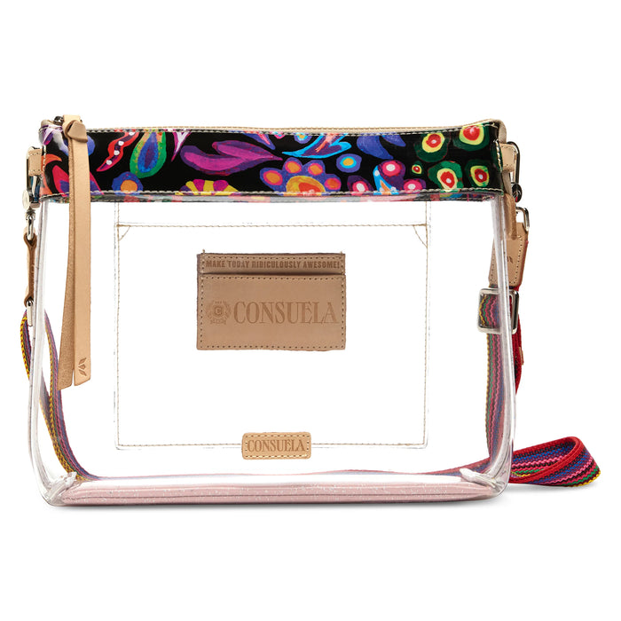 A clear plastic crossbody bag with a colorful paisley patterned top trim, beige faux-leather brand patches, and a multicolor woven strap on a white background.