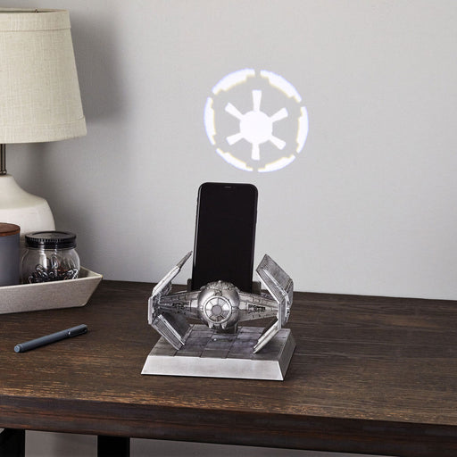 Star Wars-themed phone stand with illuminated emblem on a wooden surface