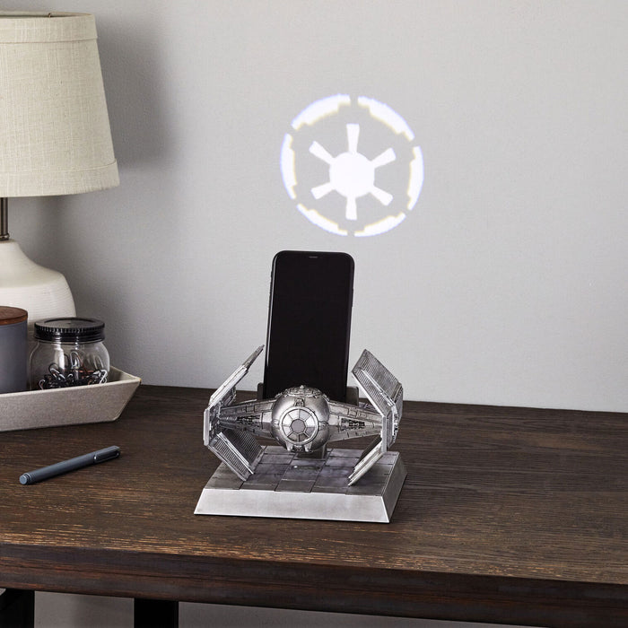 Star Wars-themed phone stand with illuminated emblem on a wooden surface