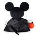 A Mickey Mouse plush toy shown from the back, wearing a black satin cape and holding an orange pumpkin, set against a plain white background.