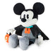 A Mickey Mouse plush toy dressed in a Halloween vampire costume, featuring a black cape, gray pinstripe shirt, orange ghost accessory, and holding an orange jack-o'-lantern, set against a plain white background.