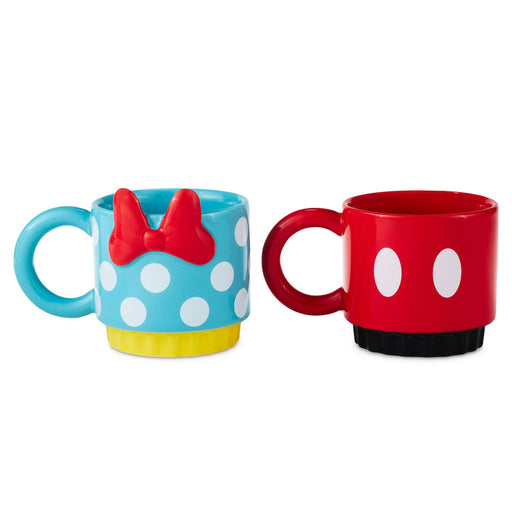Two mugs, one blue with white polka dots and a red bow, the other red with white circles, on a white background.