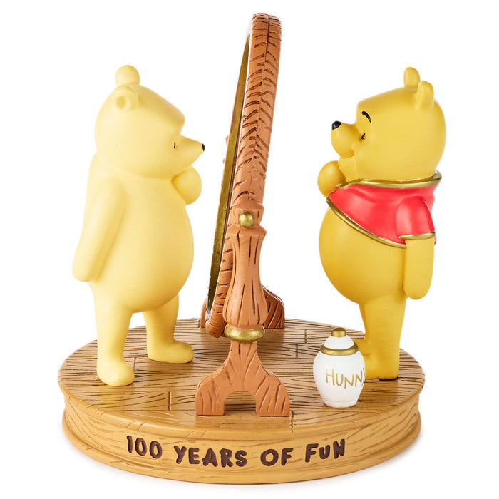 Two Winnie the Pooh figurines with a honey pot and fishing rod on a base with '100 Years of Fun' text.