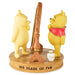 Two Winnie the Pooh figurines with a honey pot and fishing rod on a base with '100 Years of Fun' text.