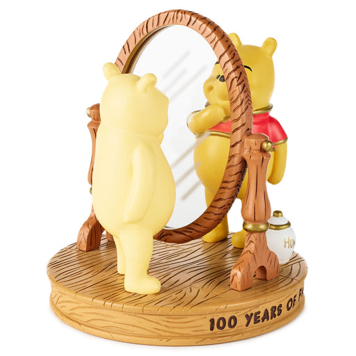 Two Winnie the Pooh figurines with a mirror on a wooden base with '100 Years of Happiness' text.