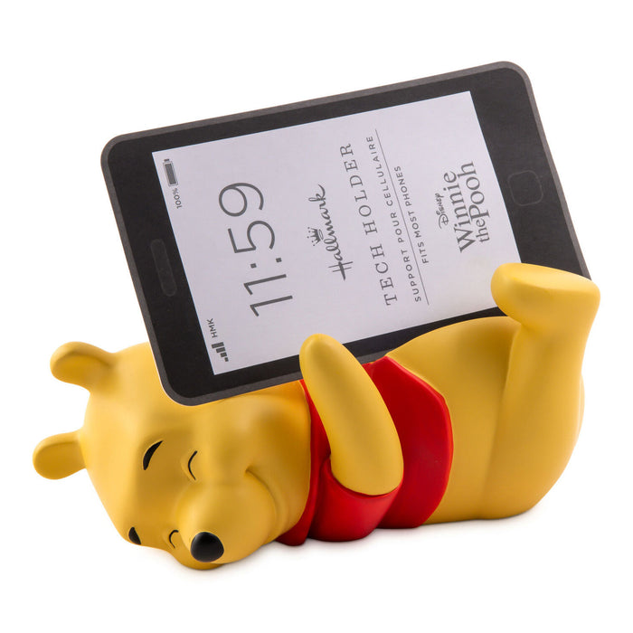 Yellow bear-shaped phone holder with a smartphone displaying text, on a white background