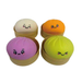 Four colorful squishy balls with smiling faces in their packaging on a white background