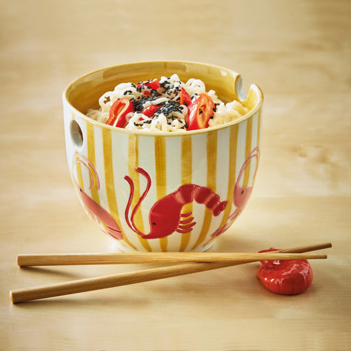 Ceramic bowl with striped design and red lobster illustration, containing a dish with noodles and vegetables on a wooden surface.