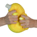 Yellow stress ball being squeezed by two hands on a white background