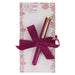 Notebook with pen and pink ribbon on floral-patterned cover