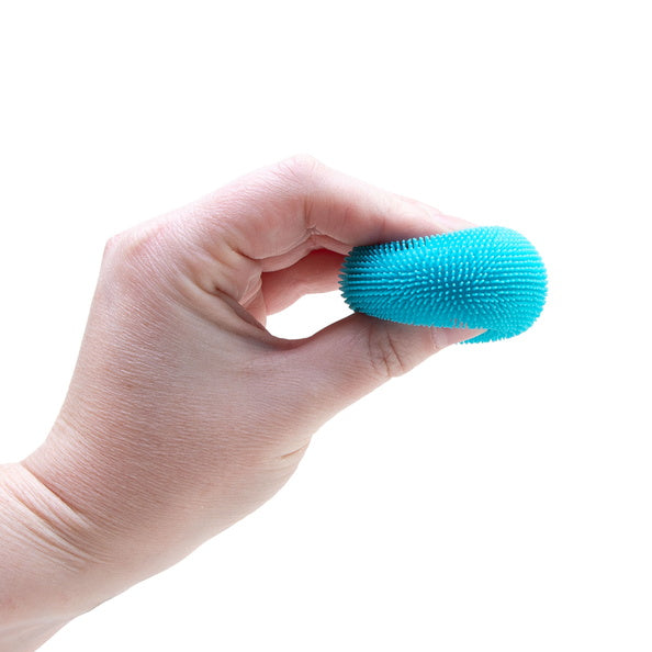 Hand holding a blue textured ball against a white background