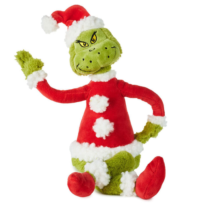 Plush toy resembling a character in a red outfit with green accents on a white background