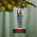 Ferris Bueller Christmas ornament hanging on a tree with a blurred green background