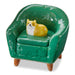 Green ceramic chair with a small dog figurine on a white background