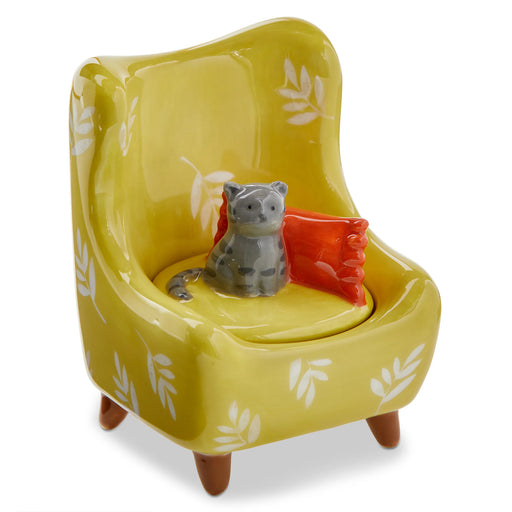 Yellow chair with a cat figurine and red cushion on a white background