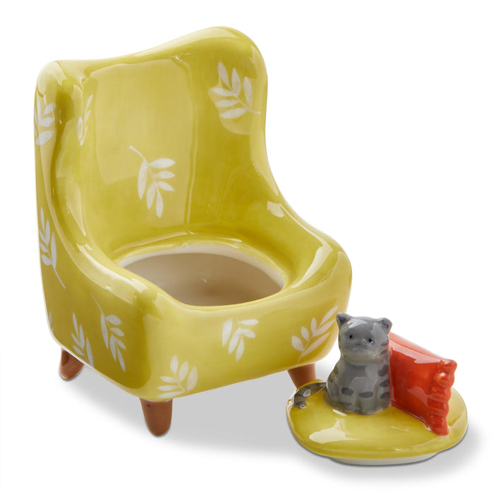 Yellow ceramic chair with a cat figurine on a white background