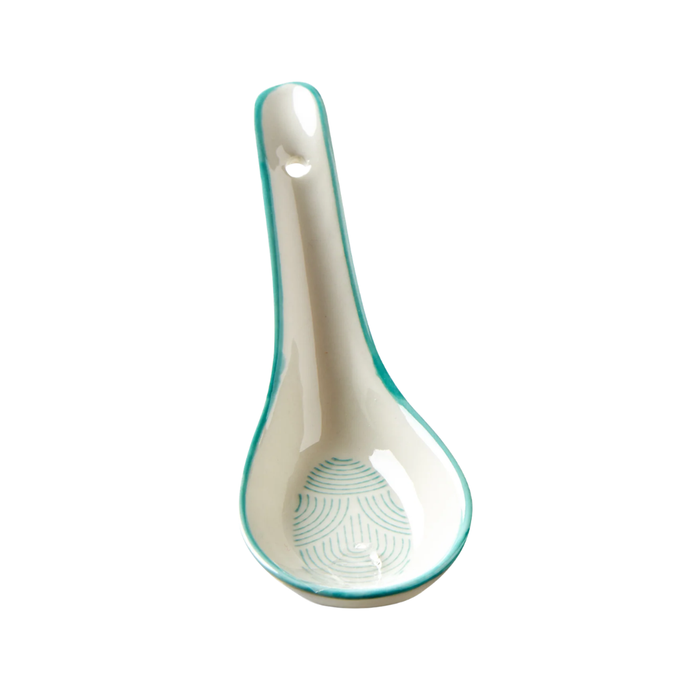 Ceramic spoon rest with turquoise rim on a white background