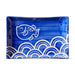Blue ceramic tray with white fish and wave patterns on a white background