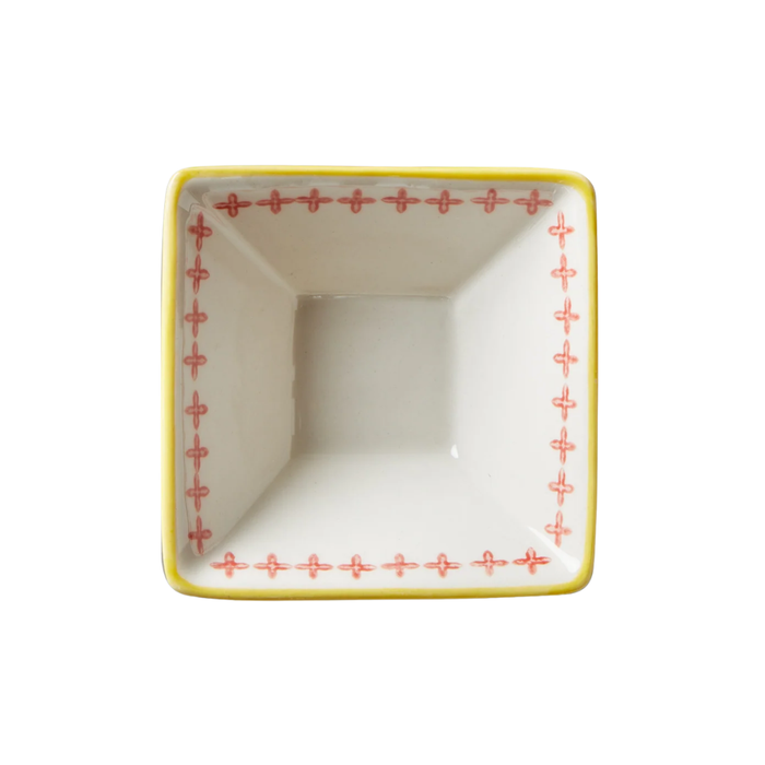 Square ceramic dish with red cross patterns on a white background