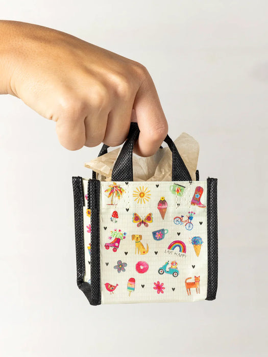 Hand holding a small bag with colorful patterns on a white background