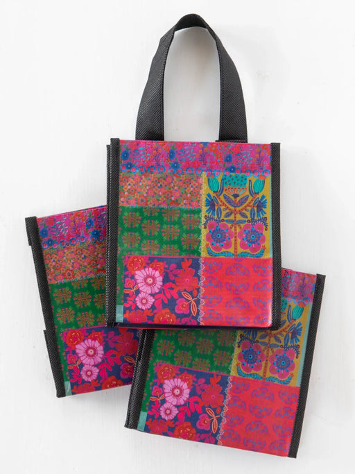 Colorful patterned bags with black handles on a white background