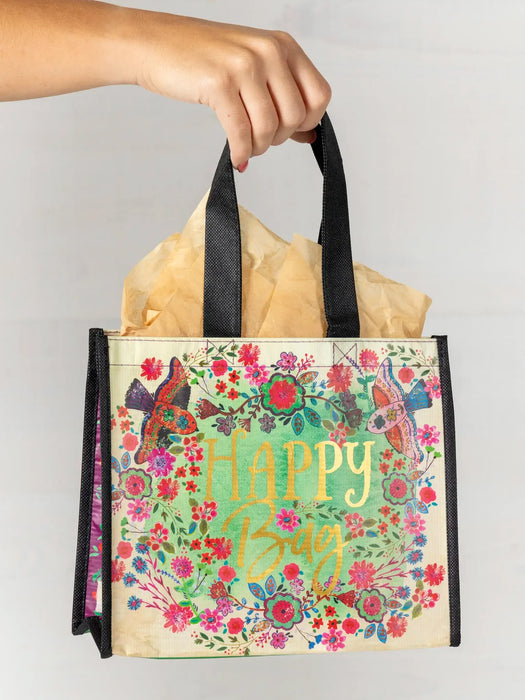 Floral and butterfly design bag with 'Happy Bag' text held by a hand against a plain background