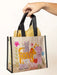 Hand holding a colorful tote bag with animal illustrations on a white background
