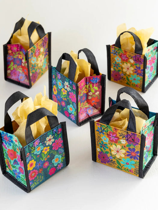 Colorful floral gift bags with handles on a white background