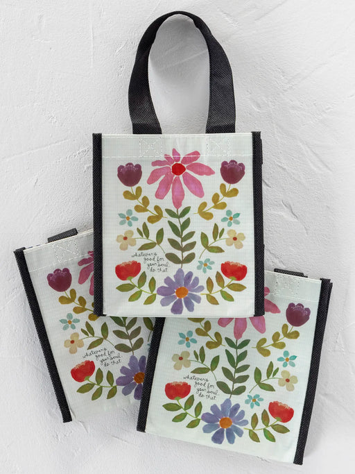 Set of three floral tote bags with black handles on a light gray background