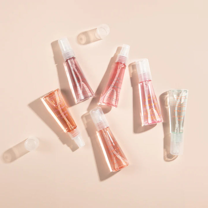 Set of transparent skincare products with white caps on a beige background