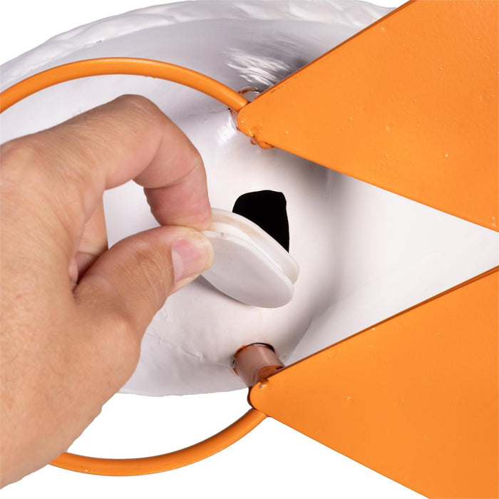 Hand plugging an orange extension cord into a white electrical outlet.