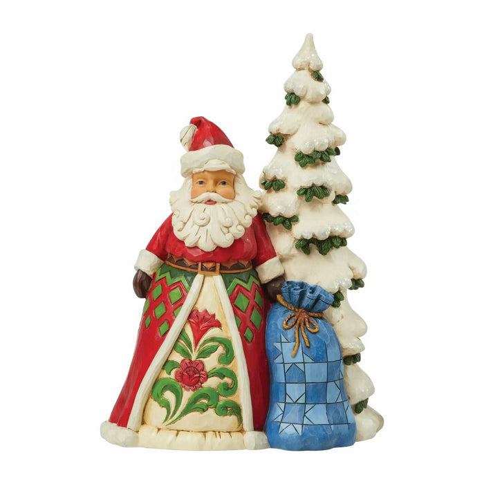 Decorative figurine of a Santa Claus holding a tree and a blue bag on a white background
