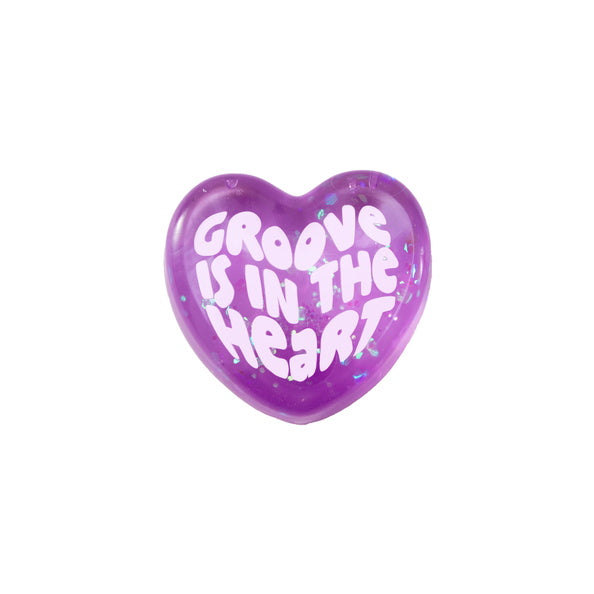 Purple heart-shaped object with 'Groove is in the Heart' text on a white background