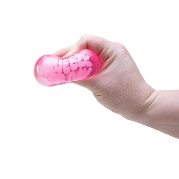 Hand holding a pink stress ball with 'SQUEEZ' text on a white background