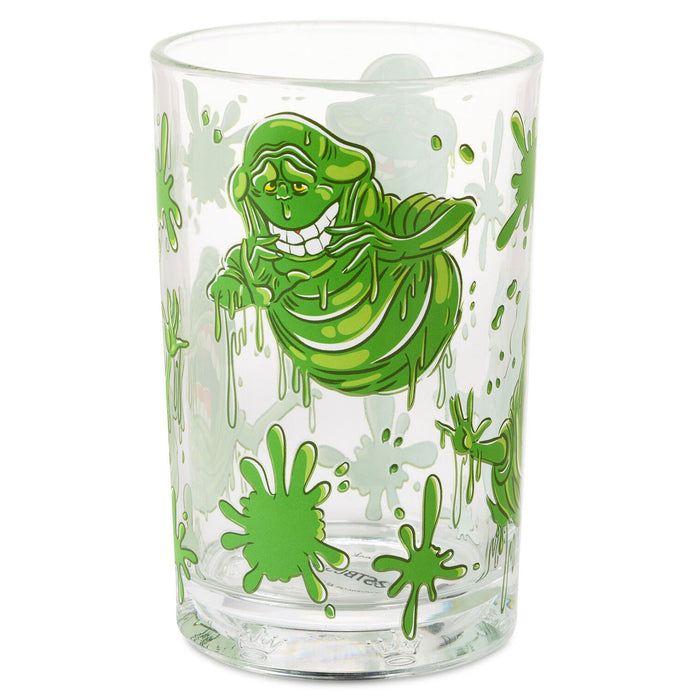 A clear glass drinking tumbler featuring a green Ghostbusters Slimer character graphic and green splatter details, shown on a plain white background.