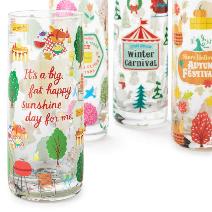 Set of colorful glass tumblers with festive designs and text on a white background