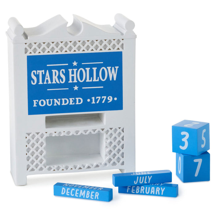 Decorative calendar with 'Stars Hollow' sign and blue blocks with numbers and months.