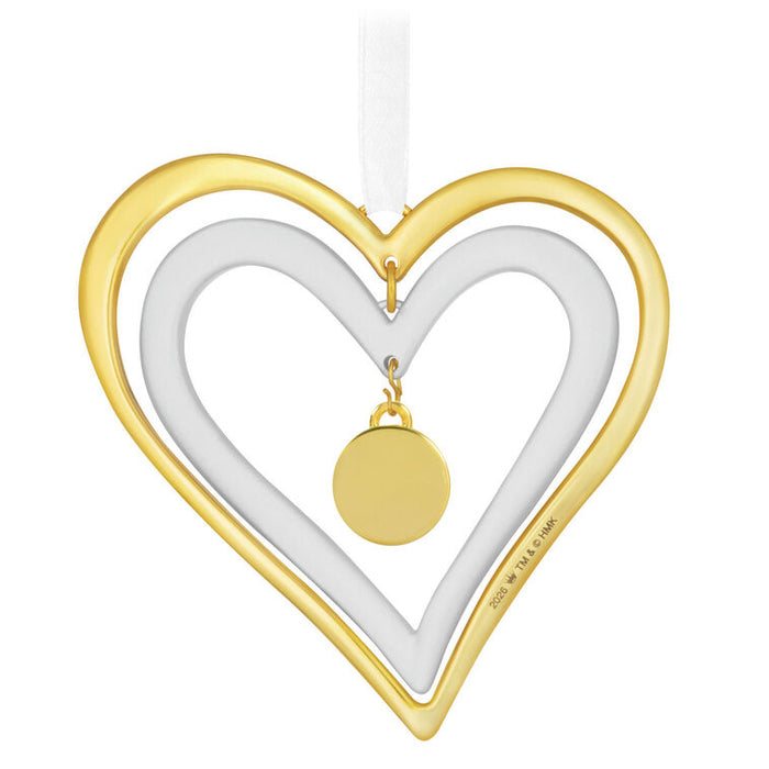 Gold and white heart-shaped pendant with a small round gold charm on a white background
