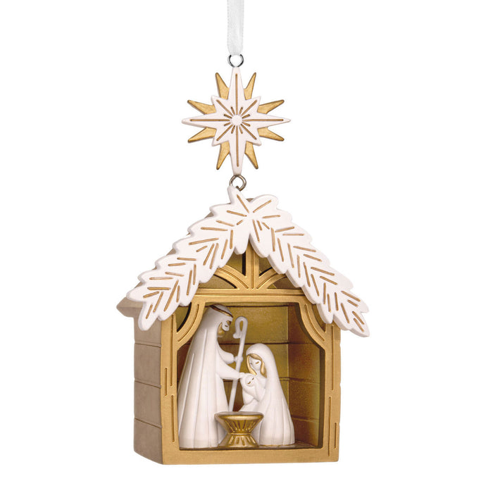 Decorative nativity scene in a wooden stable with a gold star on a white background